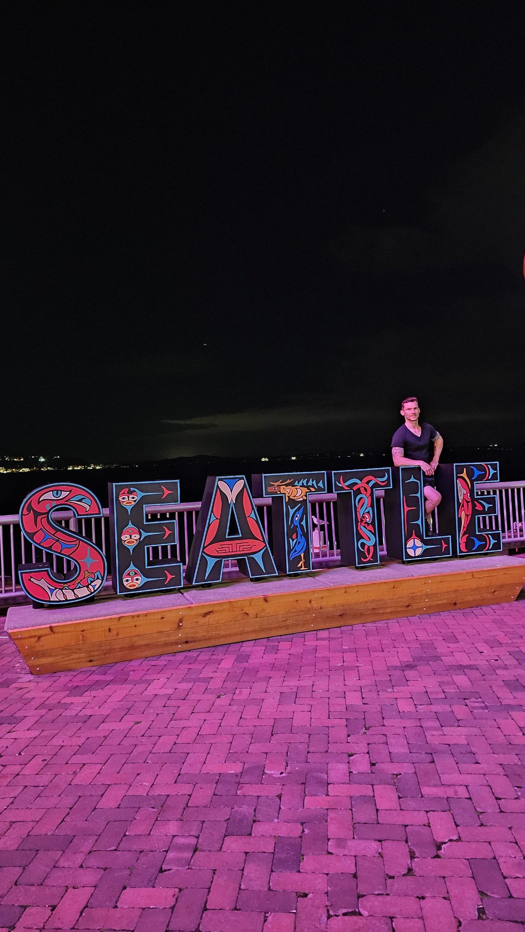 Bryan Totty at night beside the illuminated SEATTLE letters